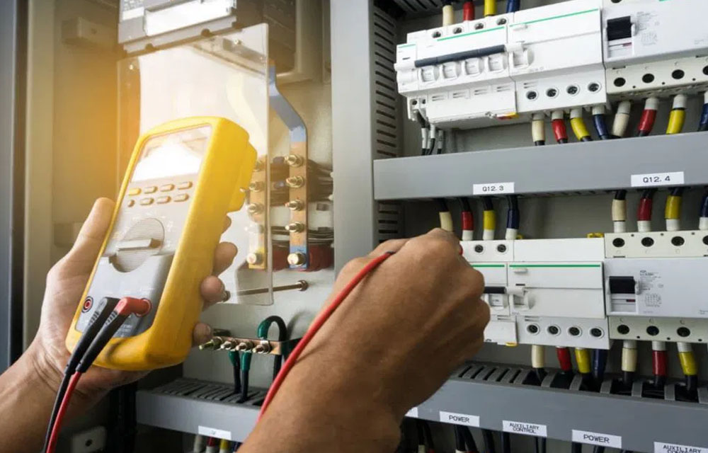 Man, an electrical technician working in a switchboard with fuses. Installation and connection of electrical equipment. Close up.