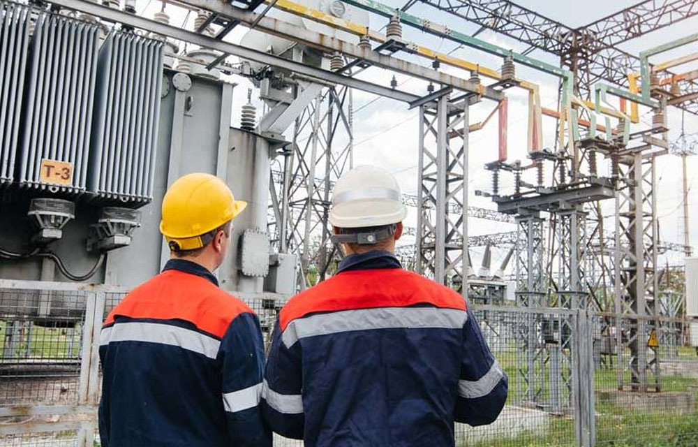 Man, an electrical technician working in a switchboard with fuses. Installation and connection of electrical equipment. Close up.